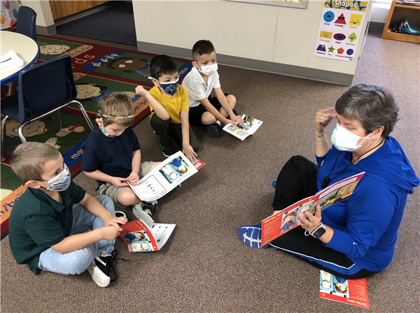 Poston reading a book to class